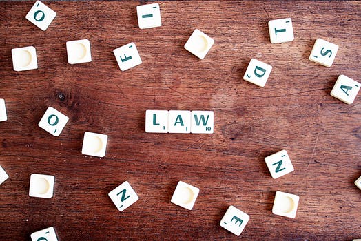 Law spelled out with scrabble tiles on a wooden table referring to the non-surgical facelift law.