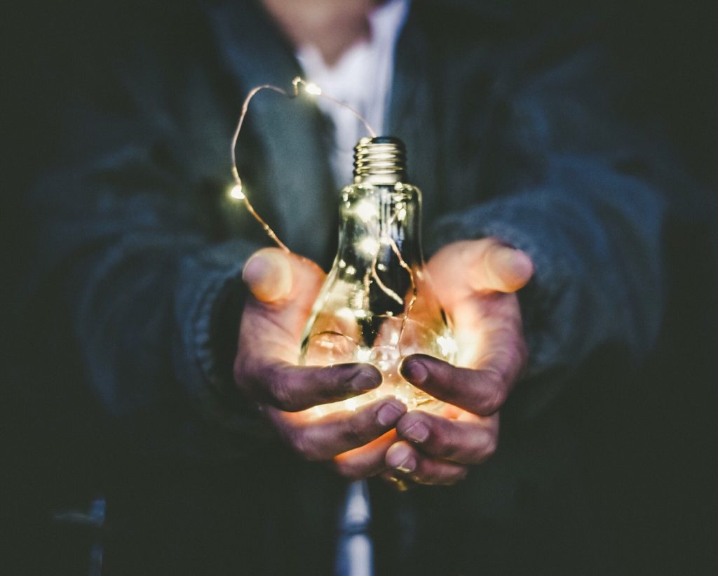 idea bulb held in palms of a mans hand